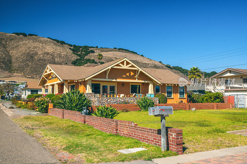 美丽的房子，漂亮的庭院前面和山的背景在加利福尼亚的一个海滩小镇。