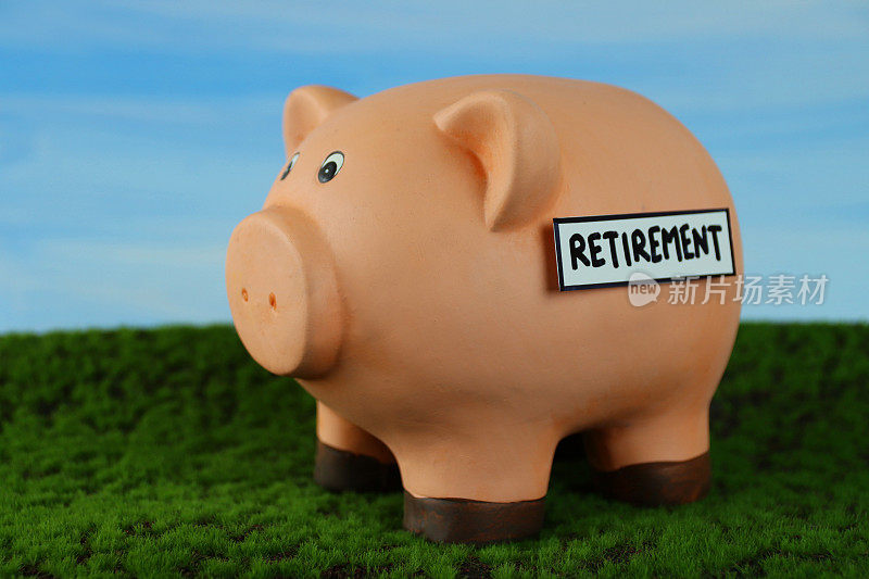 图像的小猪银行与插槽顶部与退休标签，家庭财务和储蓄的概念