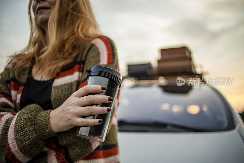 女人在公路旅行中喝咖啡-红头发的女人在旅行中，舒缓的场景