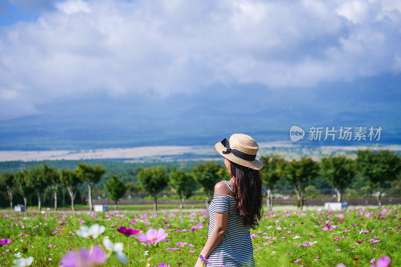 美丽的年轻女子在花圃休息