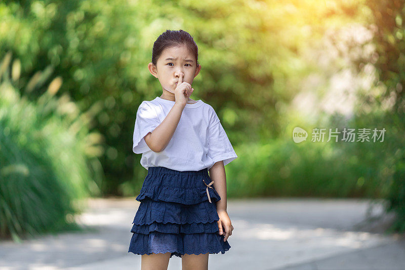 小女孩做着安静的手势