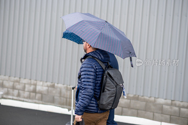 雨中的男人。手提箱。