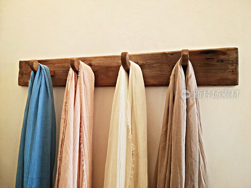 时尚多彩的围巾挂在墙上的衣架上