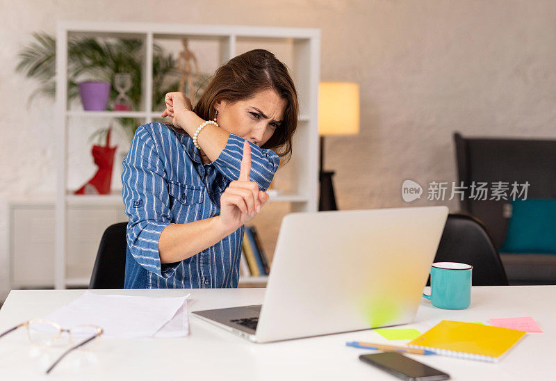 一个女人在开视频会议的时候咳嗽到肘部