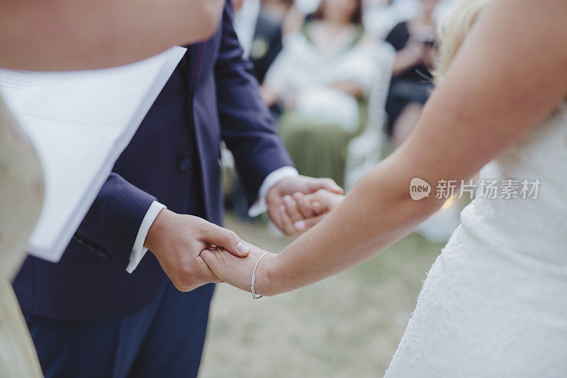 婚礼上新郎和新娘手牵手，餐桌装饰，婚礼仪式，鲜花