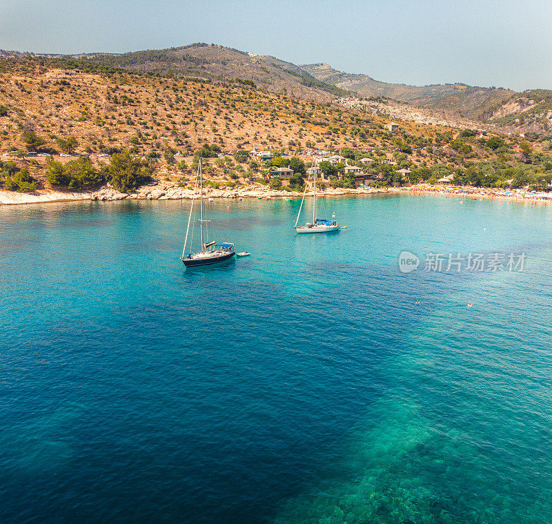 鸟瞰图的海湾和美丽的海滩在希腊岛上，帆船和海岸线与绿松石海