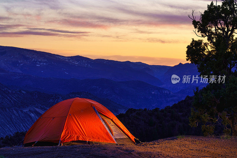 帐篷在晚上点燃与山的背景