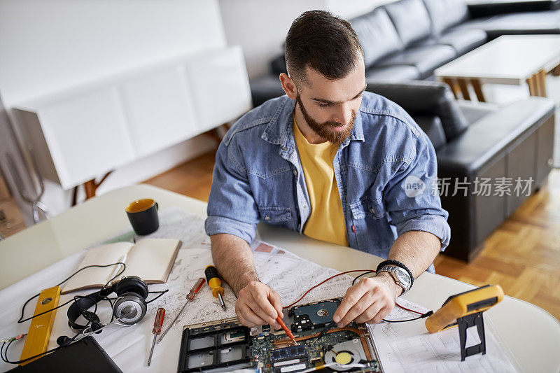 车间里的人在做他的日常工作。工作台上摆满了修理电路所需的各种工具和物品