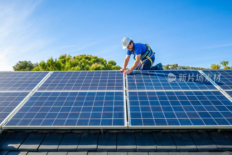 太阳能电池板安装工在现代住宅的屋顶上安装太阳能电池板