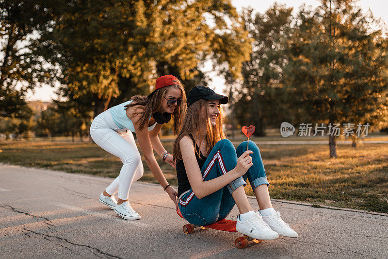 两个十几岁的女孩在城市公园玩滑板