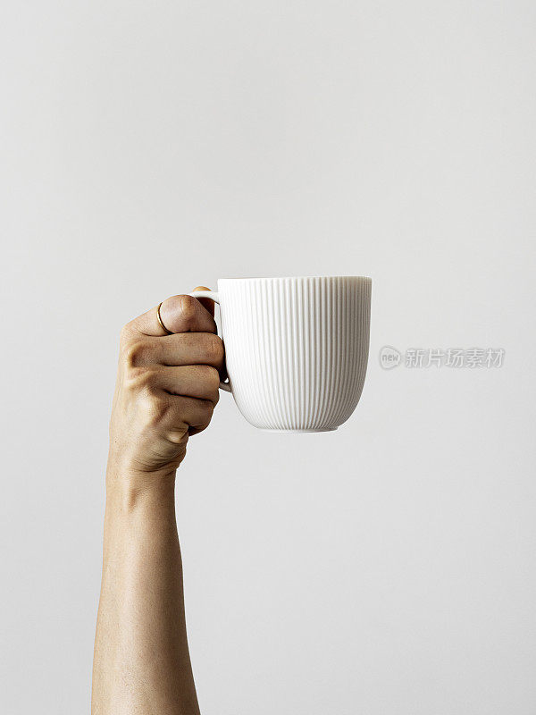 女士的手拿着咖啡杯，女士的手举着咖啡杯，新鲜的咖啡杯，手臂举着咖啡杯，