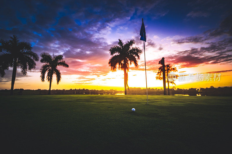 高尔夫球旁边的洞和令人惊叹的日落棕榈树剪影高尔夫在天堂
