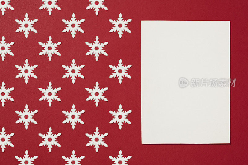 杂志封面模型与白色雪花圣诞装饰平放在红色背景