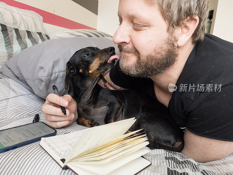当主人写笔记时，狗舔他的脸