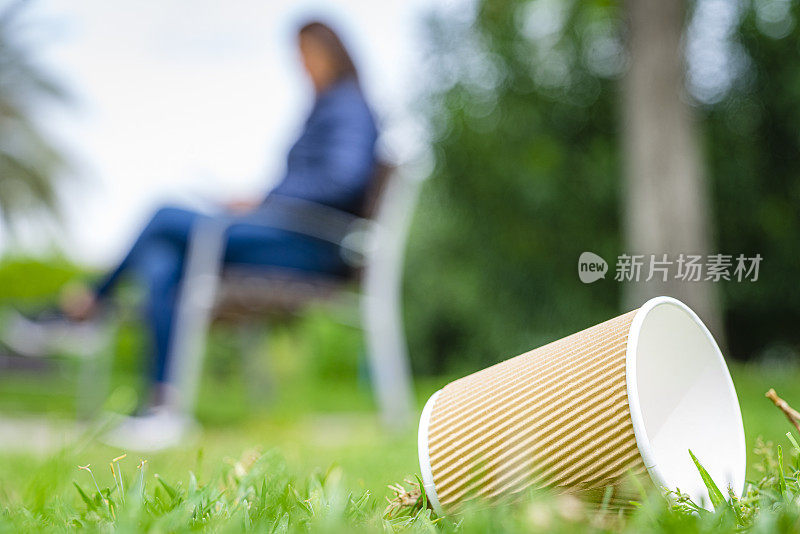 牛皮纸一次性咖啡杯被丢弃在草地上