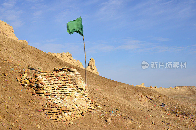 古代巴尔赫考古遗址-在巴尔赫城堡，巴尔赫省，阿富汗尼城墙西部的绿色旗帜和废墟塔