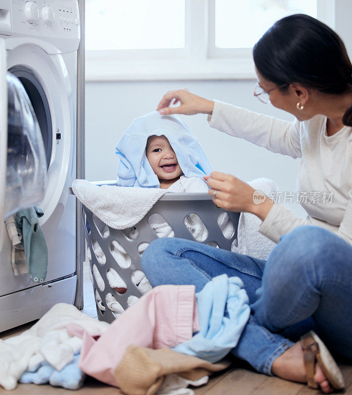 一个年轻的母亲在家里洗衣服的时候和她的小女孩玩耍