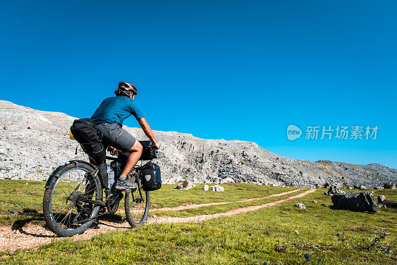 高地道路险峻地带绿色地面自行车在运动，骑自行车