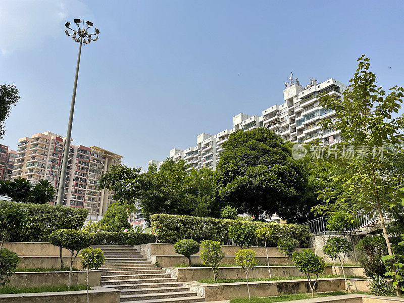 特写图像分层，公共花园铺设的楼梯和草坪，高层公寓建筑群的背景