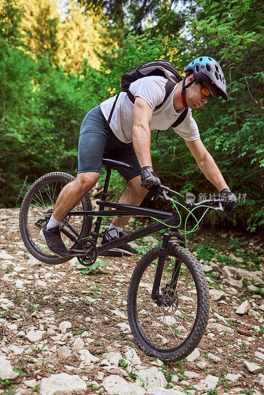 一个骑自行车的人在极端和危险的森林道路上骑自行车。有选择性的重点