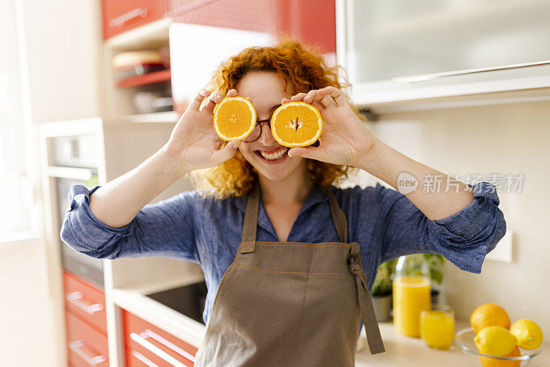 年轻女子在做橙汁的画像