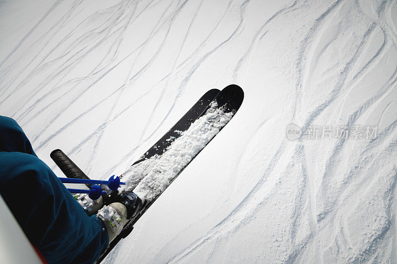 在一个美丽的日子里，一个滑雪者坐在升降椅上，阿尔卑斯山。滑雪的概念。滑雪者在滑雪缆车上的侧视图