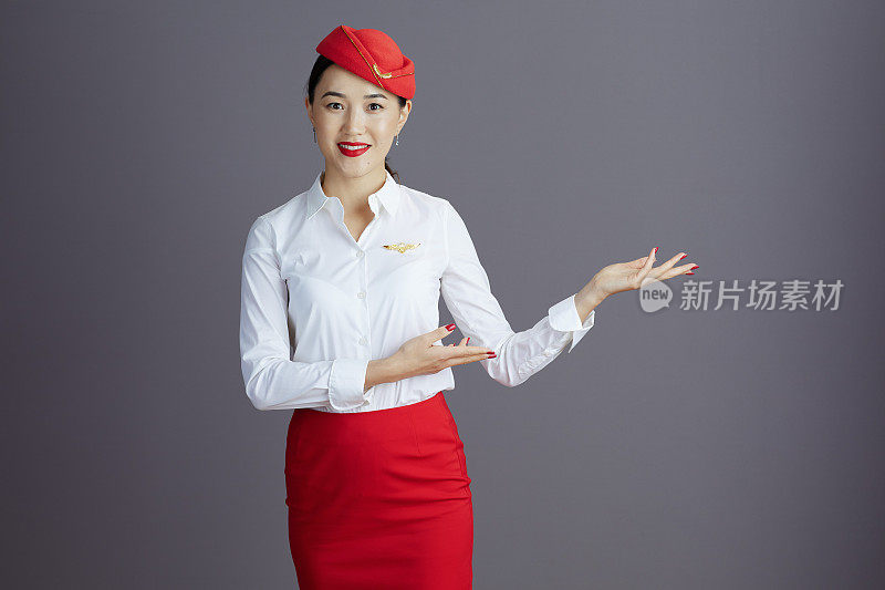 微笑的空姐亚洲妇女欢迎孤立的灰色