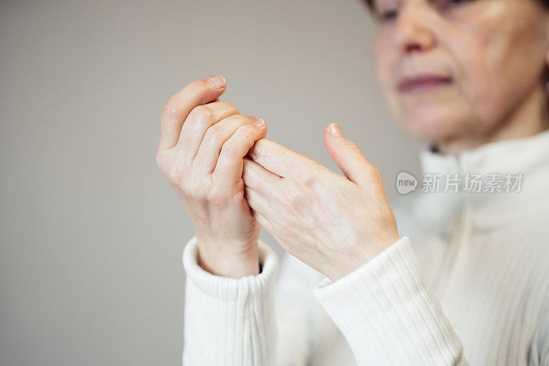 美丽的高级妇女使用护手霜的肖像