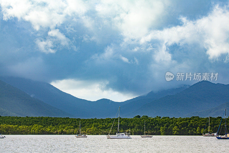 帆船和船只停泊在海湾与风暴的背景