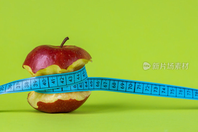 减肥理念，咬苹果相关量身计，正绿色背景，复制空间，健康美味，积极的饮食方式
