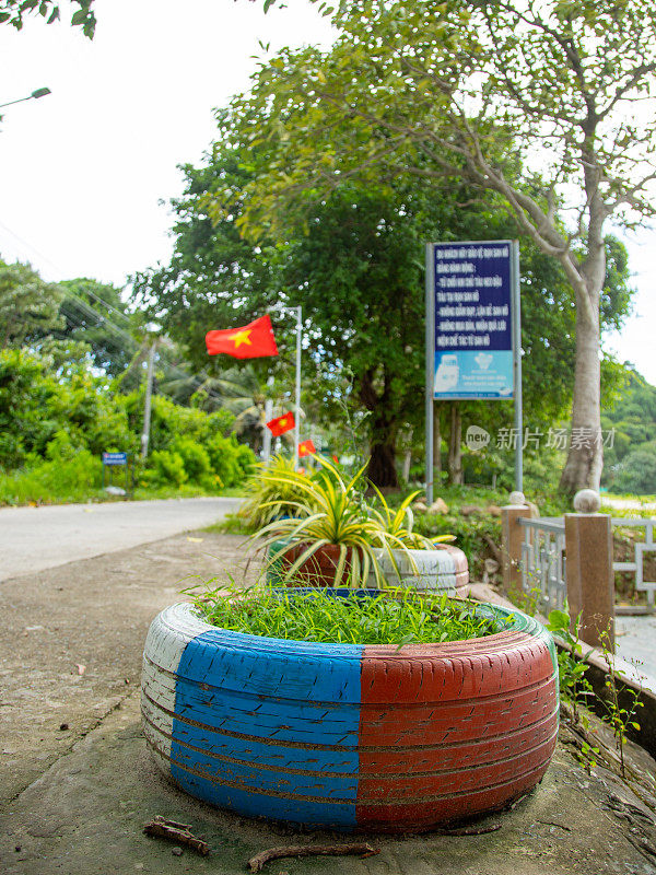 当地居民重新粉刷汽车轮胎，植树和装饰，再利用塑料材料，健江省