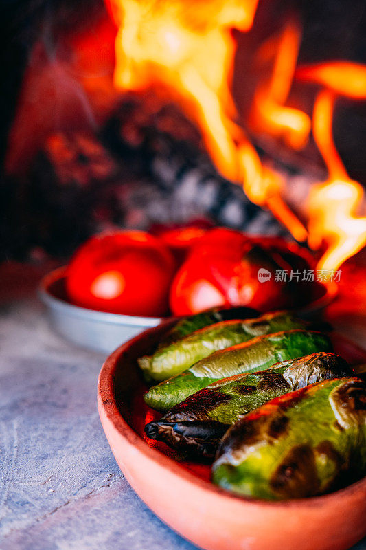 在传统的石头烤箱里煮胡椒和西红柿