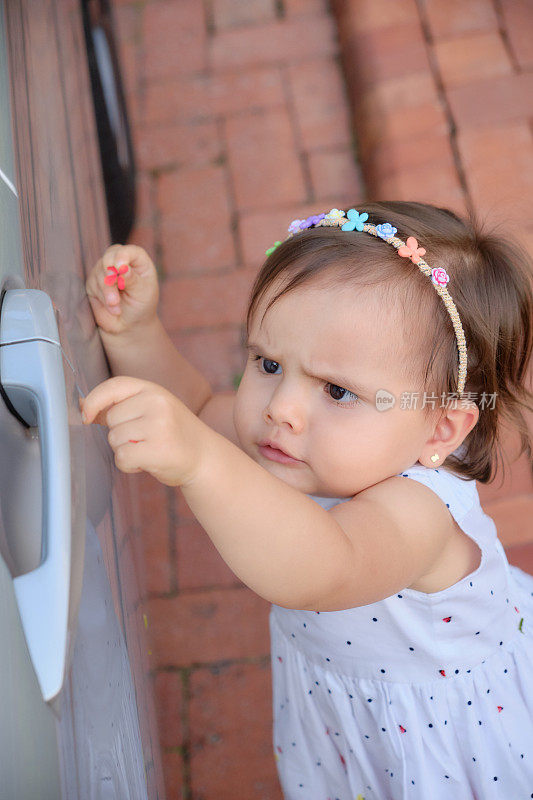 三岁的小女孩试图打开冰箱门