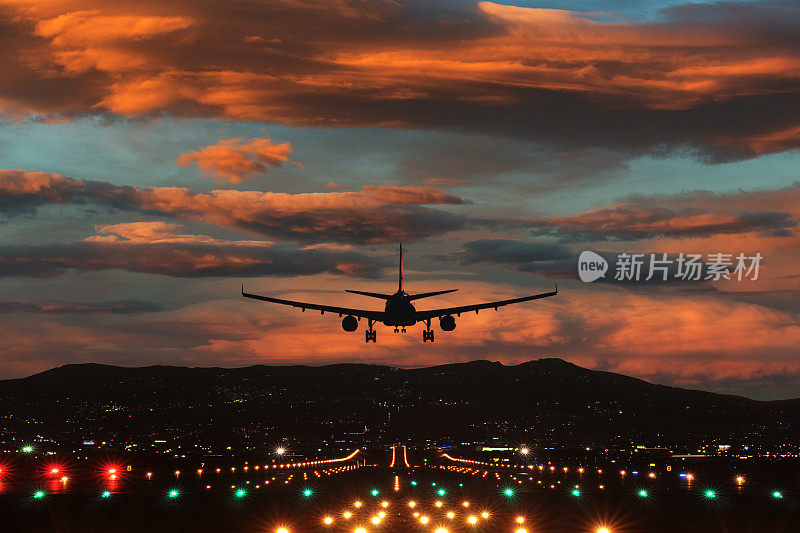 日落降落:飞机接近跑道在火热的天空