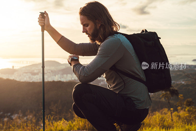 一个徒步旅行者正在享受他到达山顶的成就，并欣赏着壮丽的景色