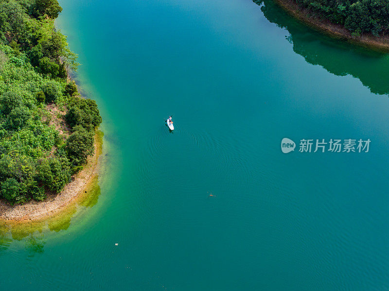 一个人划着SUP，在湖上划桨