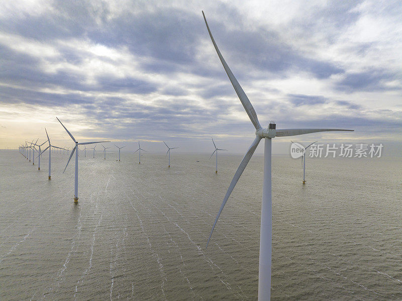 在荷兰弗莱福兰的一个海上风力发电园内，风力涡轮机产生可持续的可再生能源。无人机的视角。