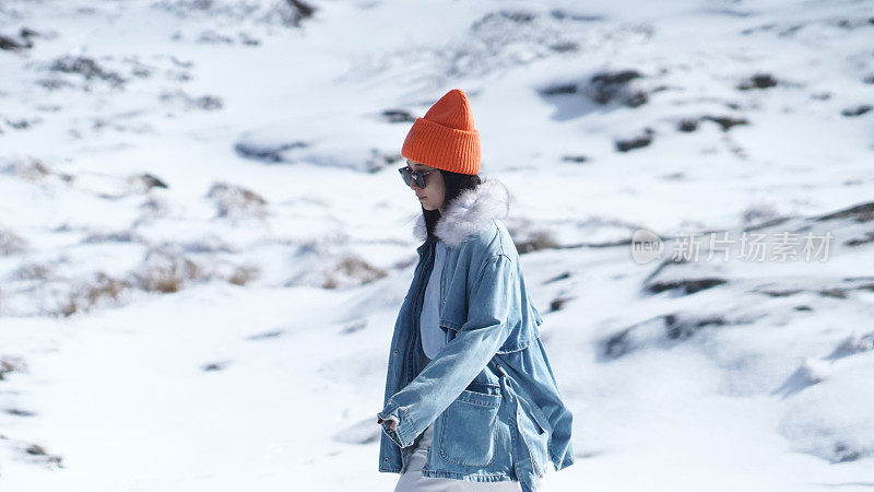 一个女人在寒冷的天气里穿行于白雪覆盖的山林之中