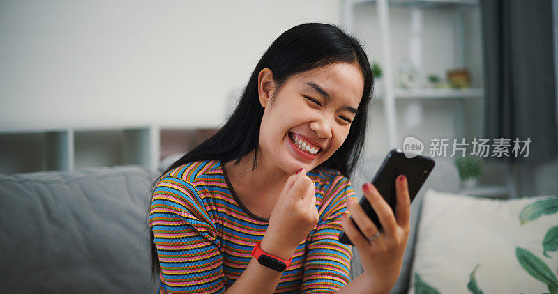 兴奋的年轻女子拿着手机阅读社交网络上的好消息通知