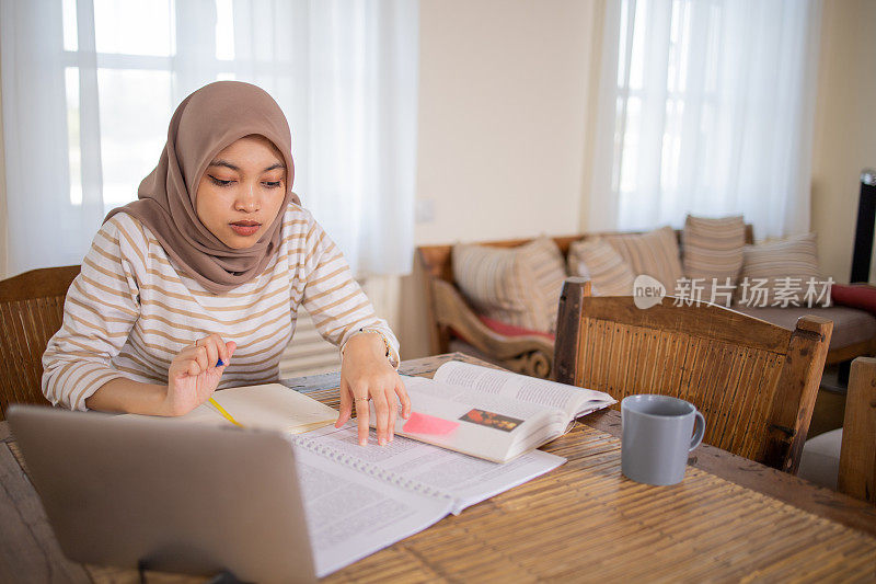 年轻女子使用计算器，同时通过账单和家庭财务