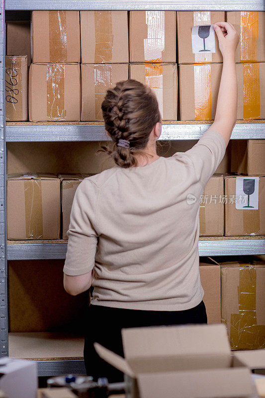 邮局工作人员在邮包箱上贴易碎或玻璃标记