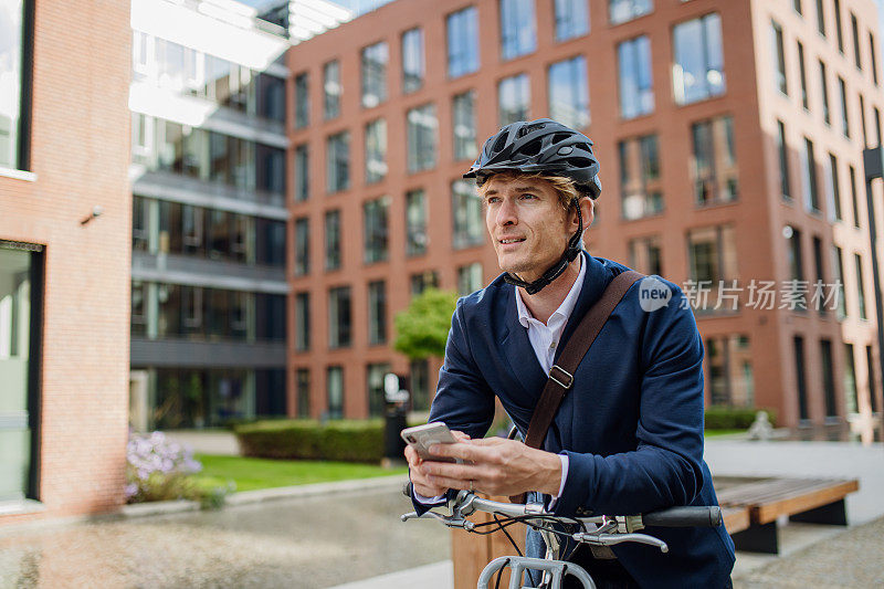 英俊的中年男子穿着西装骑着自行车在城市里穿梭。在漫长的工作日后骑自行车下班的男性城市通勤者。