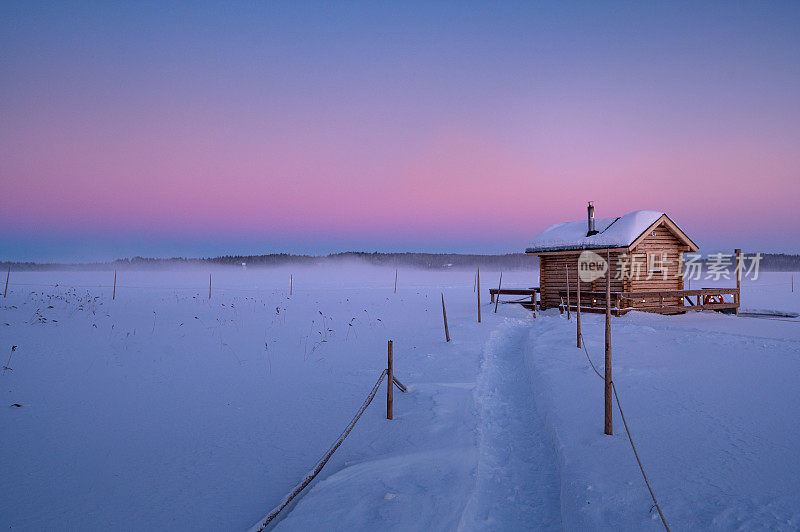 芬兰拉普兰冰湖上的桑拿浴小屋的冬日雪景
