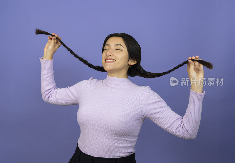 一个小女孩玩弄她的辫子的画像