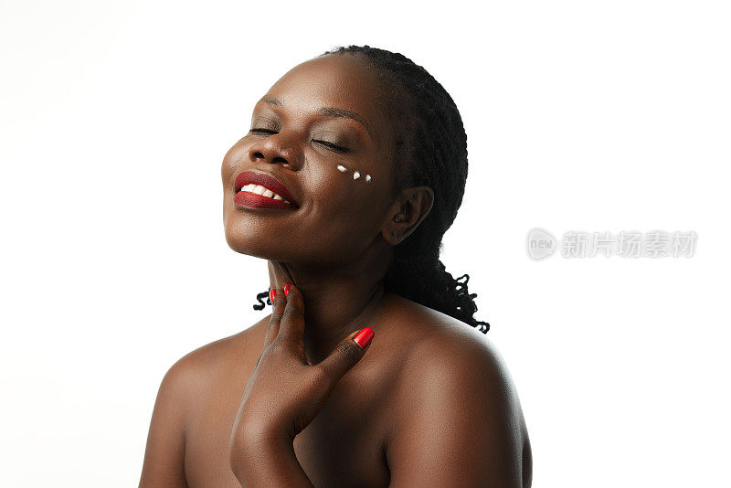 有机护肤品。阳性的非洲妇女使用面霜滋润皮肤隔离在白色的工作室背景