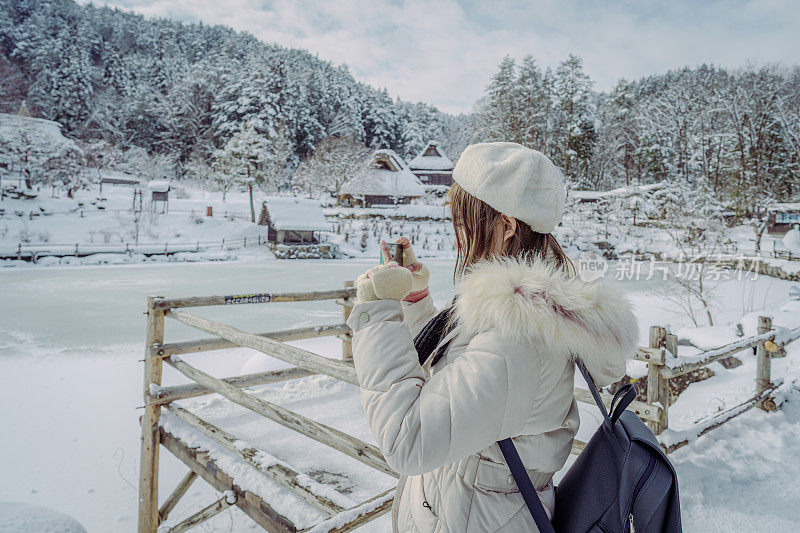 美丽的女游客享受他们的日本之旅在雪的冬天