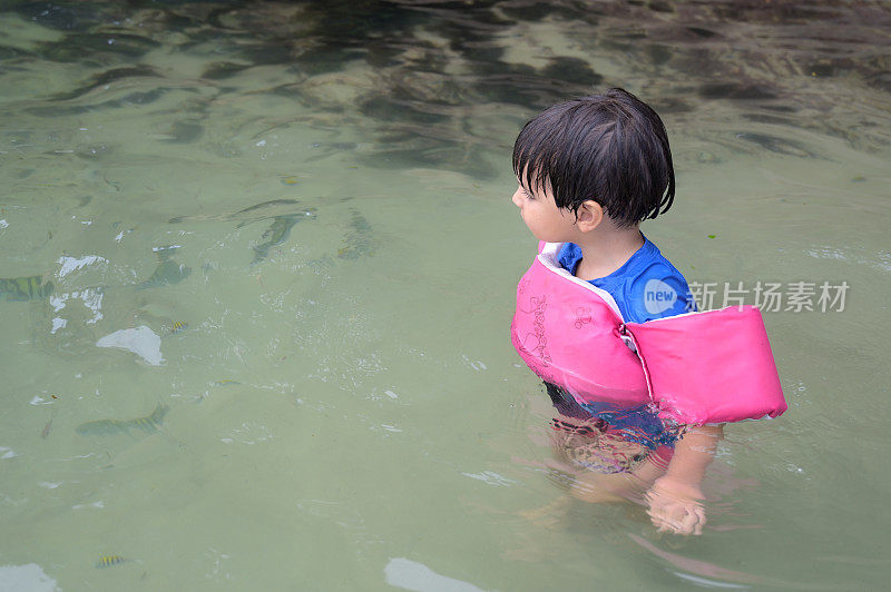 男孩在海里拿着救生圈