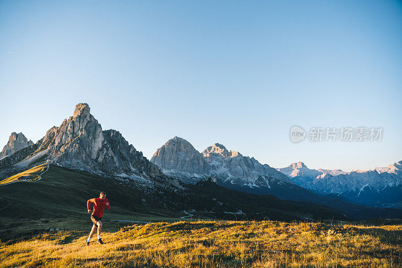 赛跑者在日出时穿过高山草甸