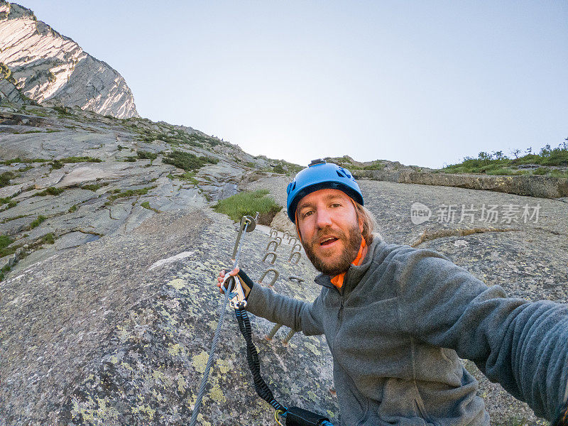 男性登山者通过ferrata自拍