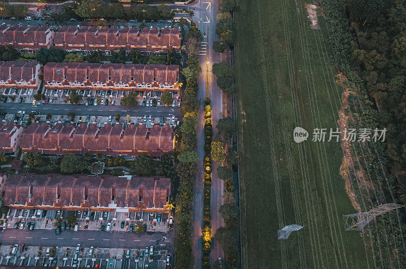 无人机直接俯瞰住宅区上方的电线塔旁，夜间有路灯